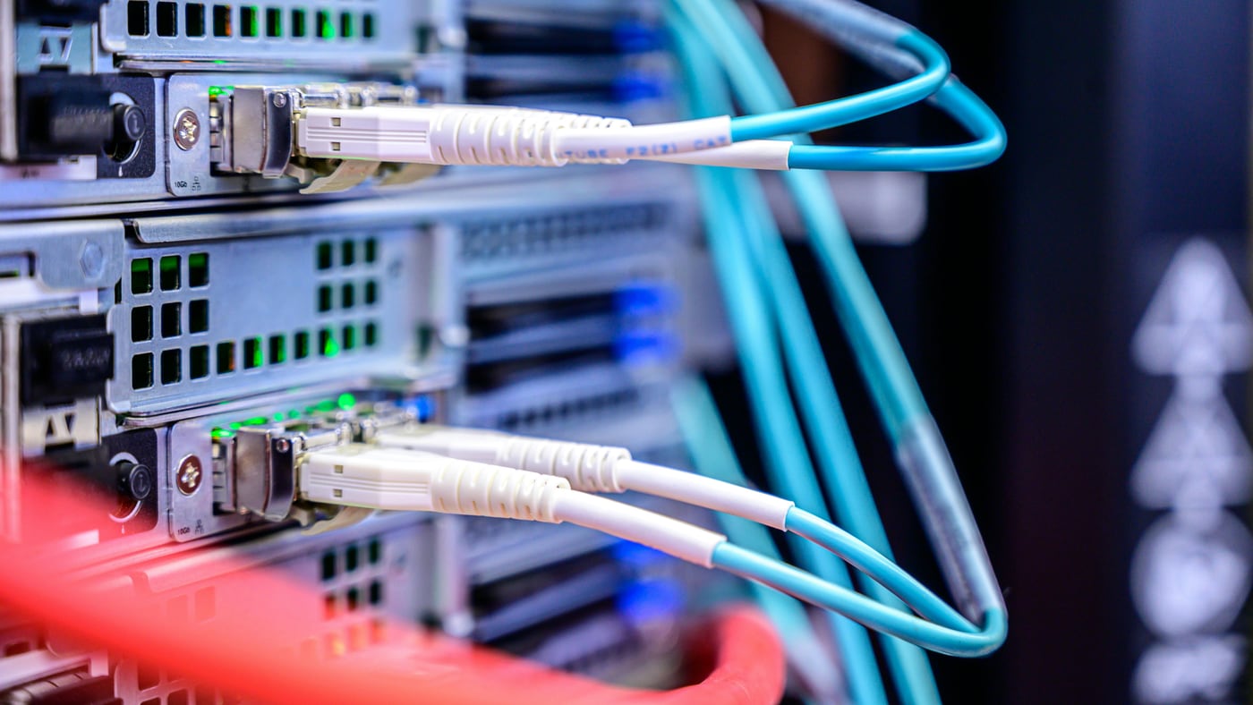 Blue fibre cross-connects patched into data centre equipment